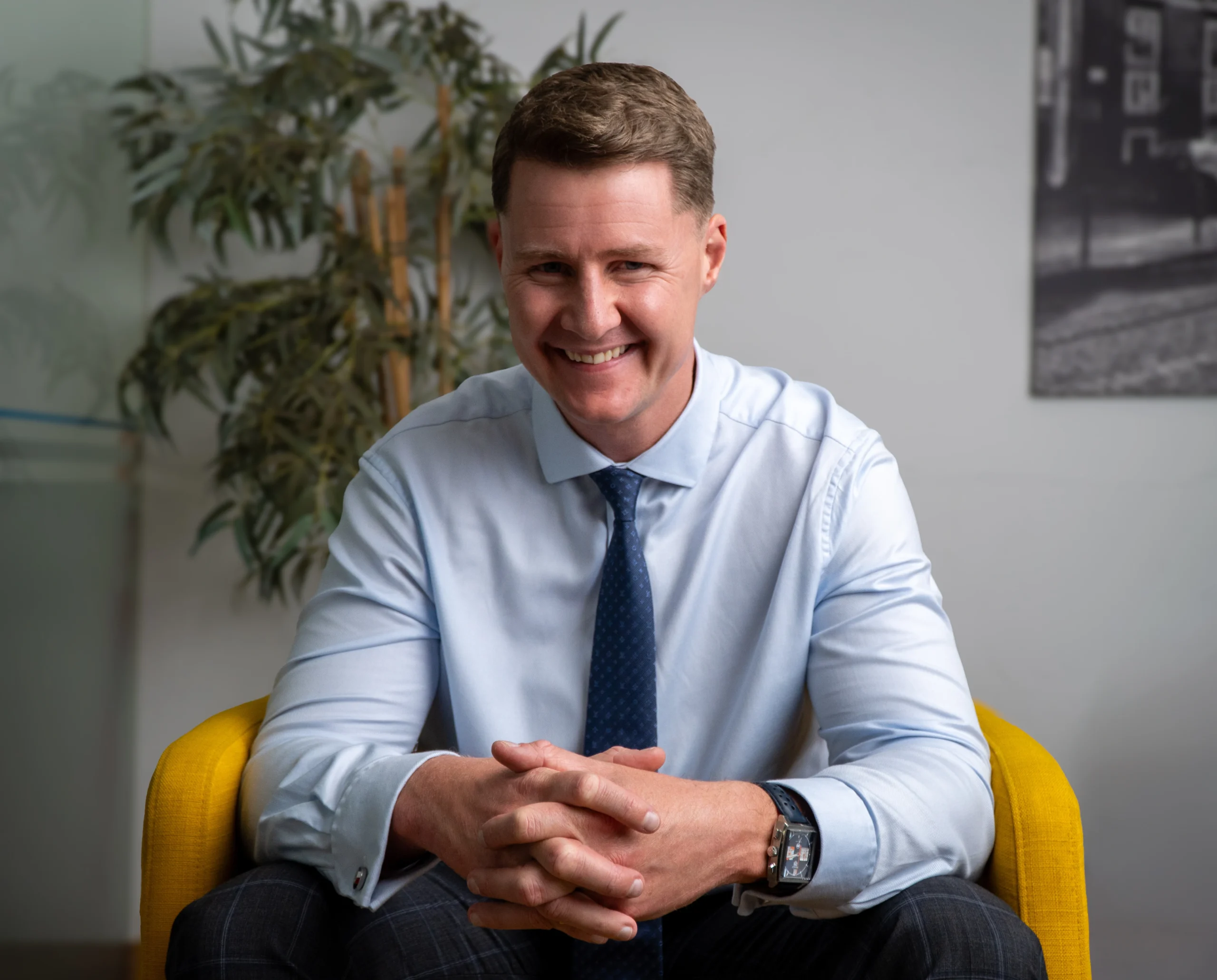 Jason Swan, founder of JS Prive, smiling confidently while seated in a modern office chair.