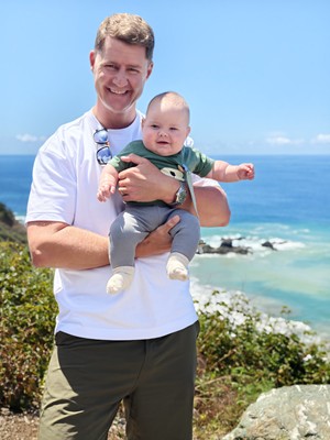 Jason Swan holding baby Max on the Big Sur coastline
