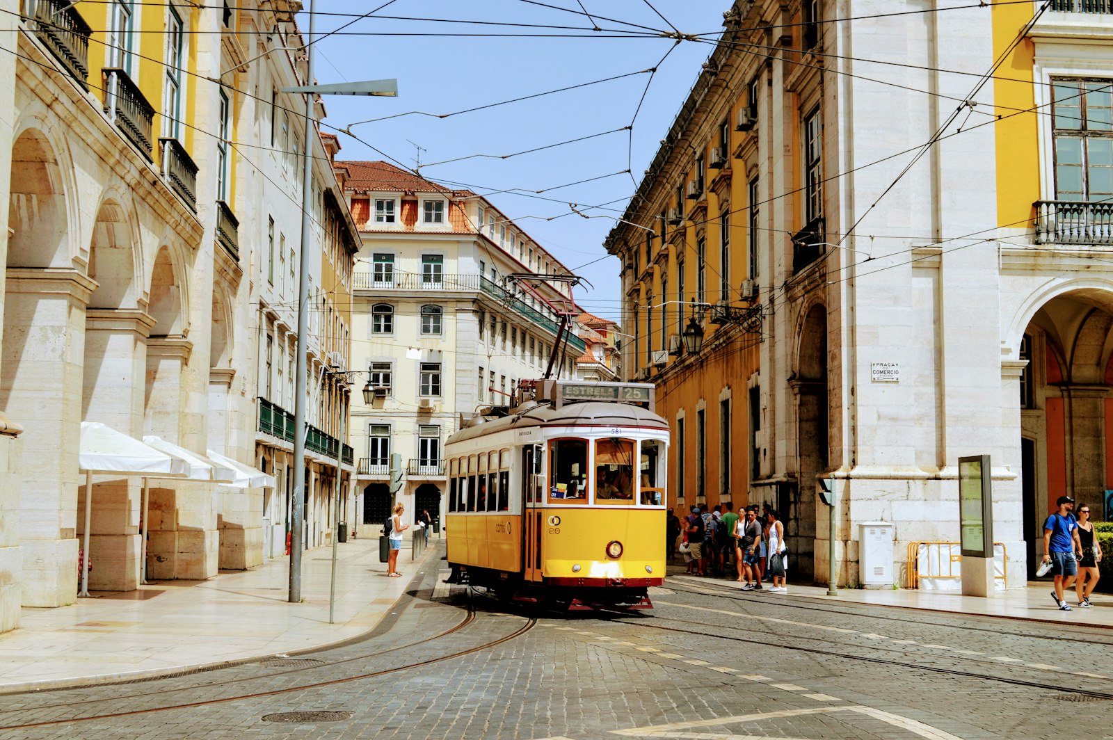 Iconic yellow Lisbon Tram 28 on a cobbled Portuguese street, representing Portugal residency and EU Long-Term Resident Status